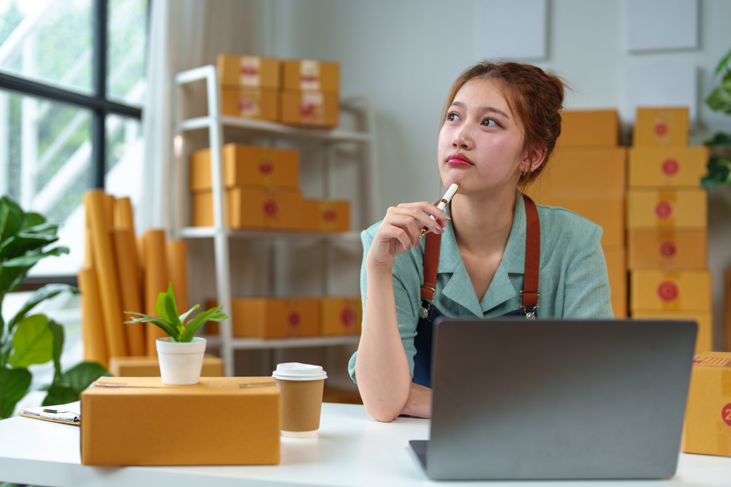 Small business owner at laptop considering payment provider options